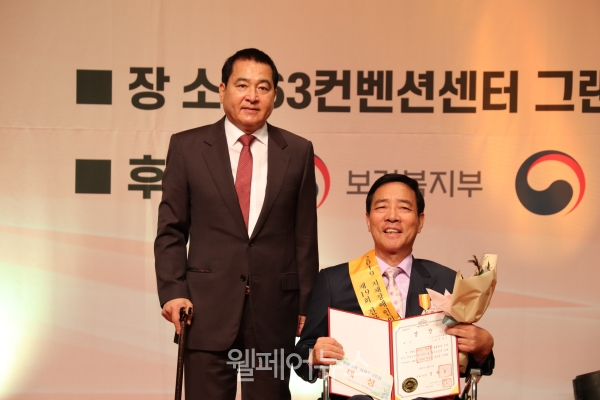 자유한국당 심재철 의원(사진 오른쪽)과 자랑스런 지체장애인상 대상을 수상한 김경식 임마누엘복지재단 이사장. Ⓒ소셜포커스