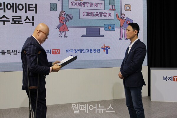 복지TV 박마루 사장(왼쪽)이 김민재 교육생에게 수료증을 전달하고 있다.