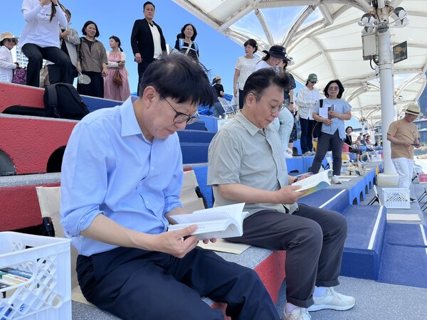 박형준 부산시장과 정연욱 국회의원이 민락수변공원 도서카페에서 책을 읽고 있다.